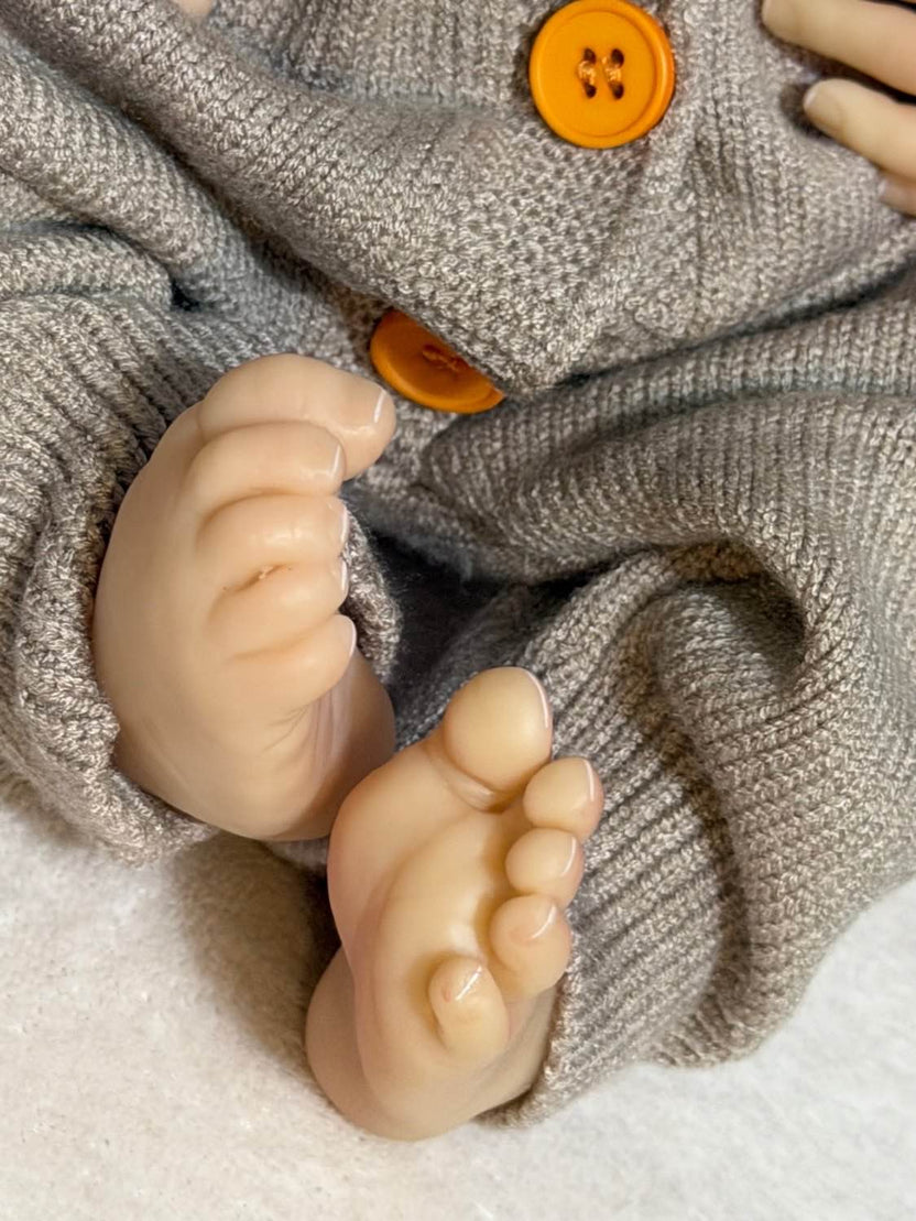 detalles de pies de bebe reborn con diseño blanco en las uñas