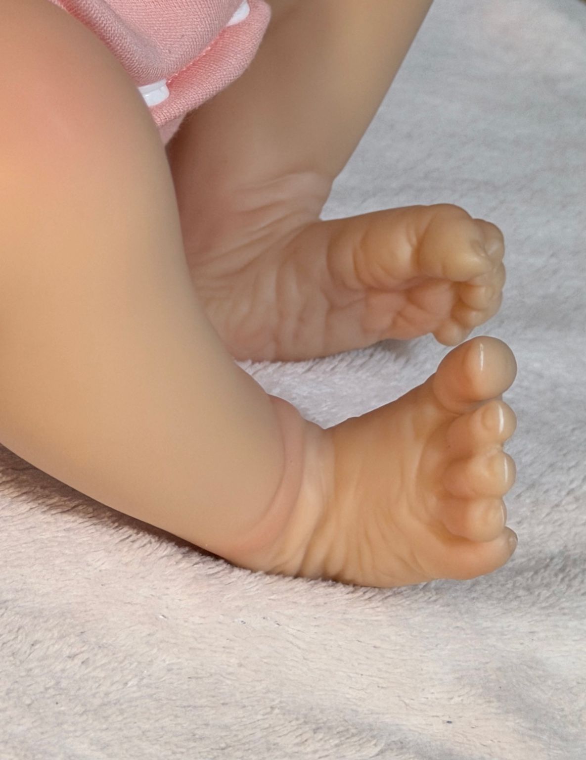 Pies realistas de muñeca reborn bebé en fondo blanco