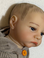 bebe reborn con vista lateral de su oreja y diseño pintado de pelo y cejas