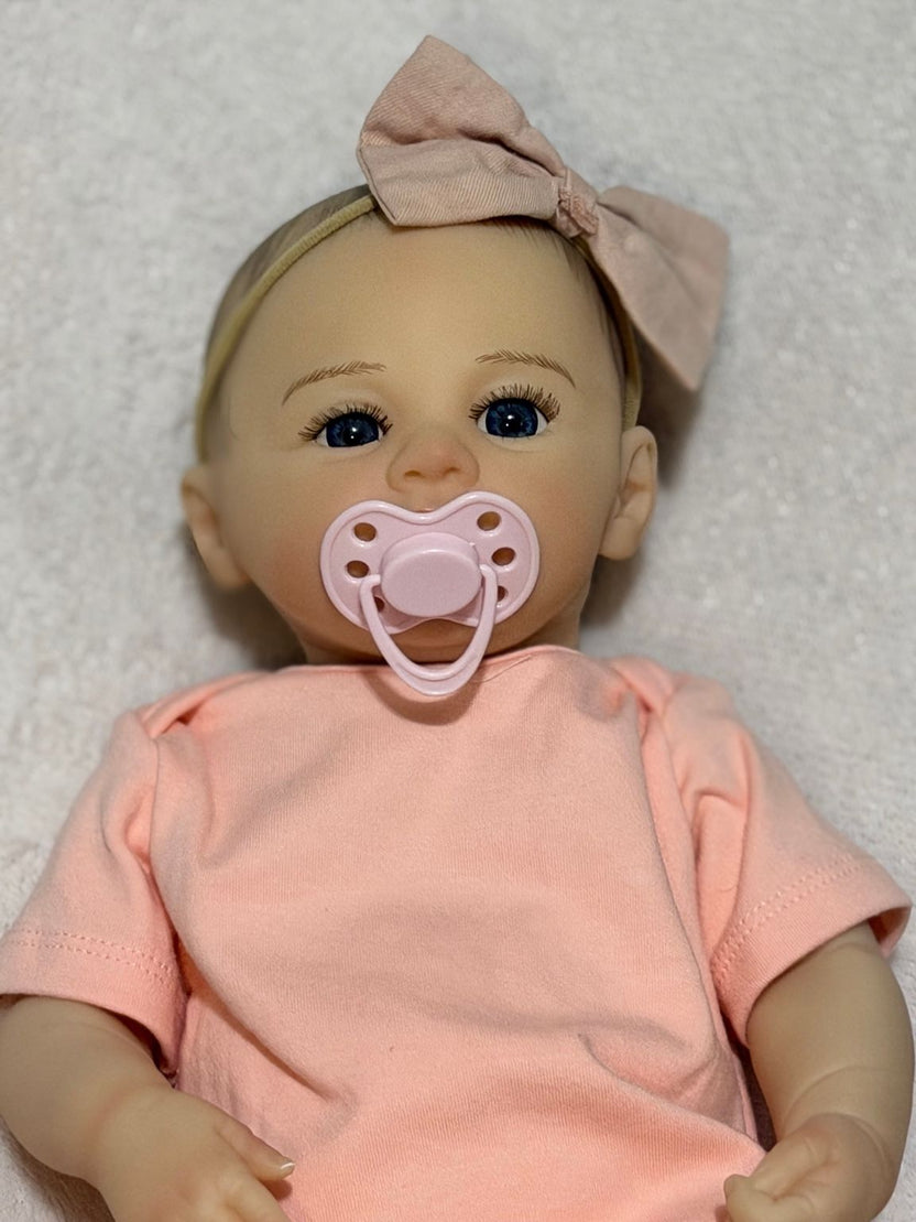 Reborn bebé realista con accesorios rosados y luz de estudio